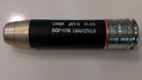 Ukrainian defense factory workers producing grenade launcher ammunition in industrial facility for frontline military use