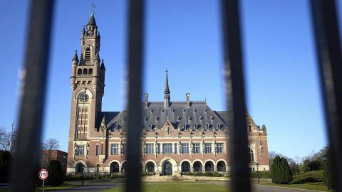 International Court of Justice building in The Hague with Ukraine flag overlay symbolizing the ICJ’s order against Russia under the Genocide Convention.