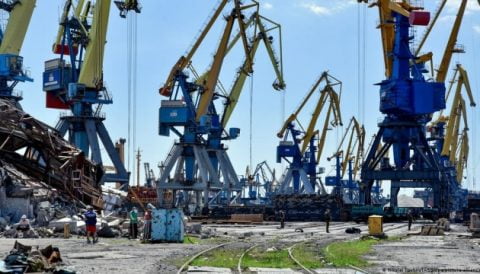 Cargo ship in Mariupol port loaded with stolen Ukrainian steel and grain, illustrating Russian forces’ exploitation of resources and forced removal of people