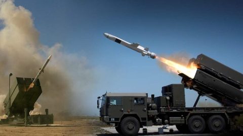 Ukrainian city under bombardment with smoke rising and air defense systems responding to repeated Russian missile and artillery attacks