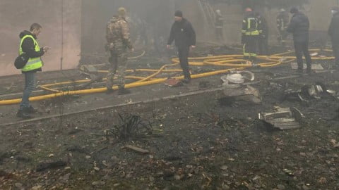 Aftermath of the Brovary helicopter crash in Kyiv Oblast near a kindergarten with emergency crews, damaged buildings and rescue response.
