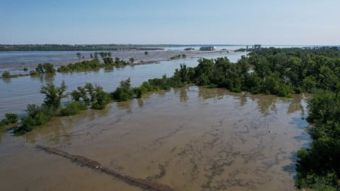 Flooded riverbanks in Zaporizhzhia Oblast after Russian troops blew up dam structures near Novodarivka with rising waters impacting farmland and villages.