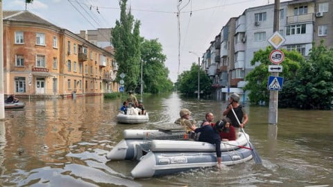 Evacuation convoy and families fleeing flood zone near Kakhovka dam devastation, Ukrainian authorities helping displaced residents amid rising waters.
