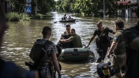 Flooded neighborhoods after Kakhovka dam destruction with rescue crews and submerged homes, reflecting rising deaths and missing civilians.