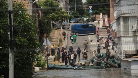 Evacuation route in Kherson region under attack by Russian drones and artillery, showing damaged rescue vehicles and fleeing civilians