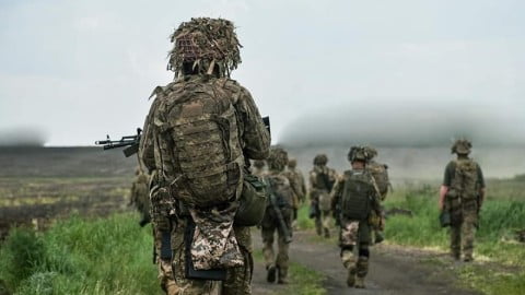 Ukrainian troops advancing under combat conditions on active frontline positions during intense Russia-Ukraine war counteroffensive operations