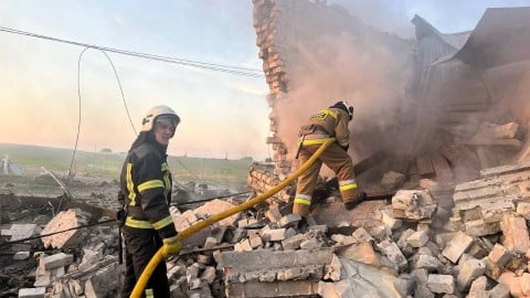 Explosions and smoke over Ukrainian city skyline after an overnight Russian missile attack as air defense fires light the night sky in war‑torn landscapes.