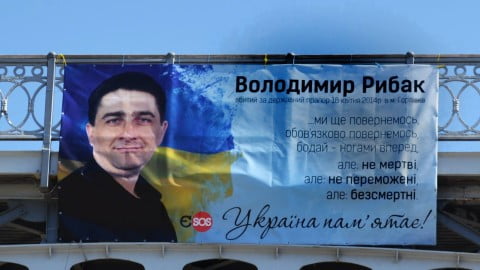 Volodymyr Rybak’s family standing by memorial banner on Instytutska Street, calling for urgent help and support due to critical needs. :contentReference[oaicite:1]{index=1}