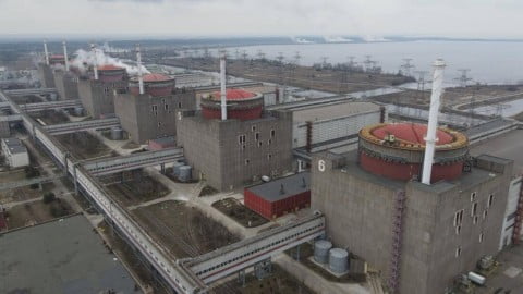 Aerial view of the occupied Zaporizhzhia Nuclear Power Plant with smoke and military presence highlighting nuclear risk concerns