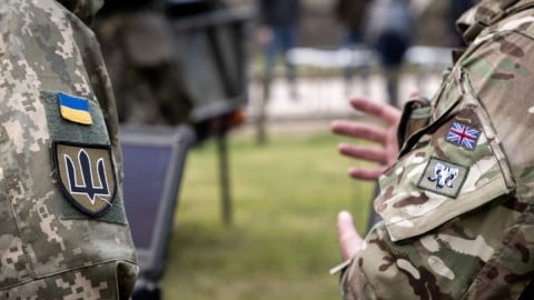 Ukrainian soldiers and officers studying English with NATO training materials in military classrooms as part of new language proficiency initiative.