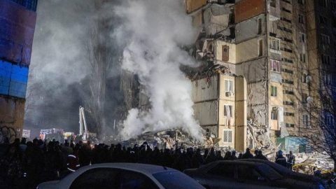Destroyed entrance of Odesa high-rise after Russian drone strike with debris, shattered windows, and emergency crews on scene