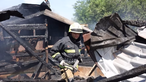 Aftermath of Russian missile strike in Dnipro with destroyed buildings, smoke rising and emergency crews rescuing civilians from rubble.