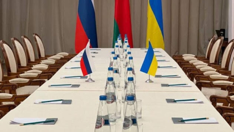 Diplomats and world leaders at a Ukraine peace negotiation table with documents and flags as speculation swirls over a revealed peace plan.