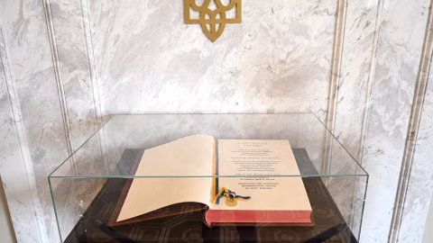 Historic Ukrainian constitution document with national symbols, highlighting the evolution from the 1710 Pylyp Orlyk charter to the modern 1996 Constitution.