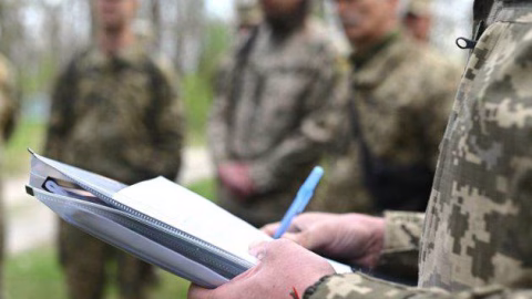 Ukrainian recruitment center sign and lines outside, representing the nationwide debate over disbanding territorial military recruitment centers amid rights concerns. :contentReference[oaicite:1]{index=1}