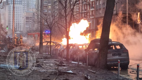 Emergency responders clearing debris and damaged buildings in Kyiv after a Russian attack — smoke, rubble and rescue crews in action.