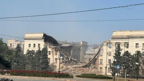 Damaged Kherson Regional Administration building after massive Russian guided bomb attack with smoke, debris and shattered facade in city center