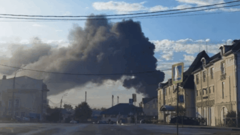Smoke rising over an industrial site in Russia’s Rostov region after reported drone attack with emergency response vehicles at scene