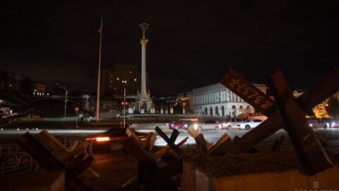 Maidan Nezalezhnosti in central Kyiv during a blackout, darkened streets and silhouettes symbolizing war, energy collapse, and resilience
