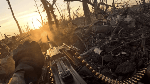 Scene from 2000 Meters to Andriyivka documentary showing Ukrainian soldiers in rugged terrain as cameras track their advance.