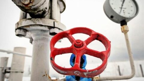 Darkened Kyiv skyline during winter outages contrasted with gas pipelines, symbolizing the cost of past energy decisions