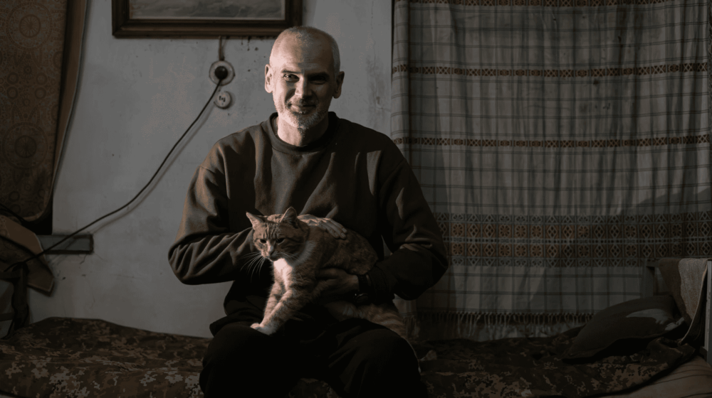 Ukrainian infantry dug into a frontline position amid harsh terrain and drones overhead, symbolizing extended rotations and frontline endurance.