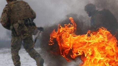 Ukrainian defenders and frontline vehicles amid smoke and explosions as mass drone and missile strikes unfold during February 17, 2026 Russia-Ukraine conflict escalation.