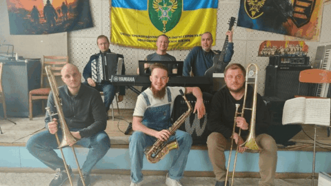 Ukrainian border guard ensemble performing for soldiers near frontline, providing morale and psychological support during wartime