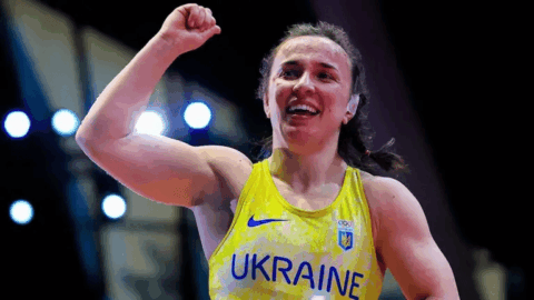 Ukrainian athlete on podium during European Championship as national anthem plays after victory over Russian competitor