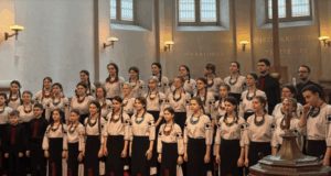 Kyiv children’s choir Shchedryk performing on stage in Prague church with audience standing during emotional wartime concert