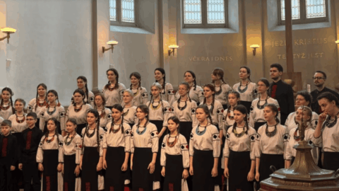 Kyiv children’s choir Shchedryk performing on stage in Prague church with audience standing during emotional wartime concert